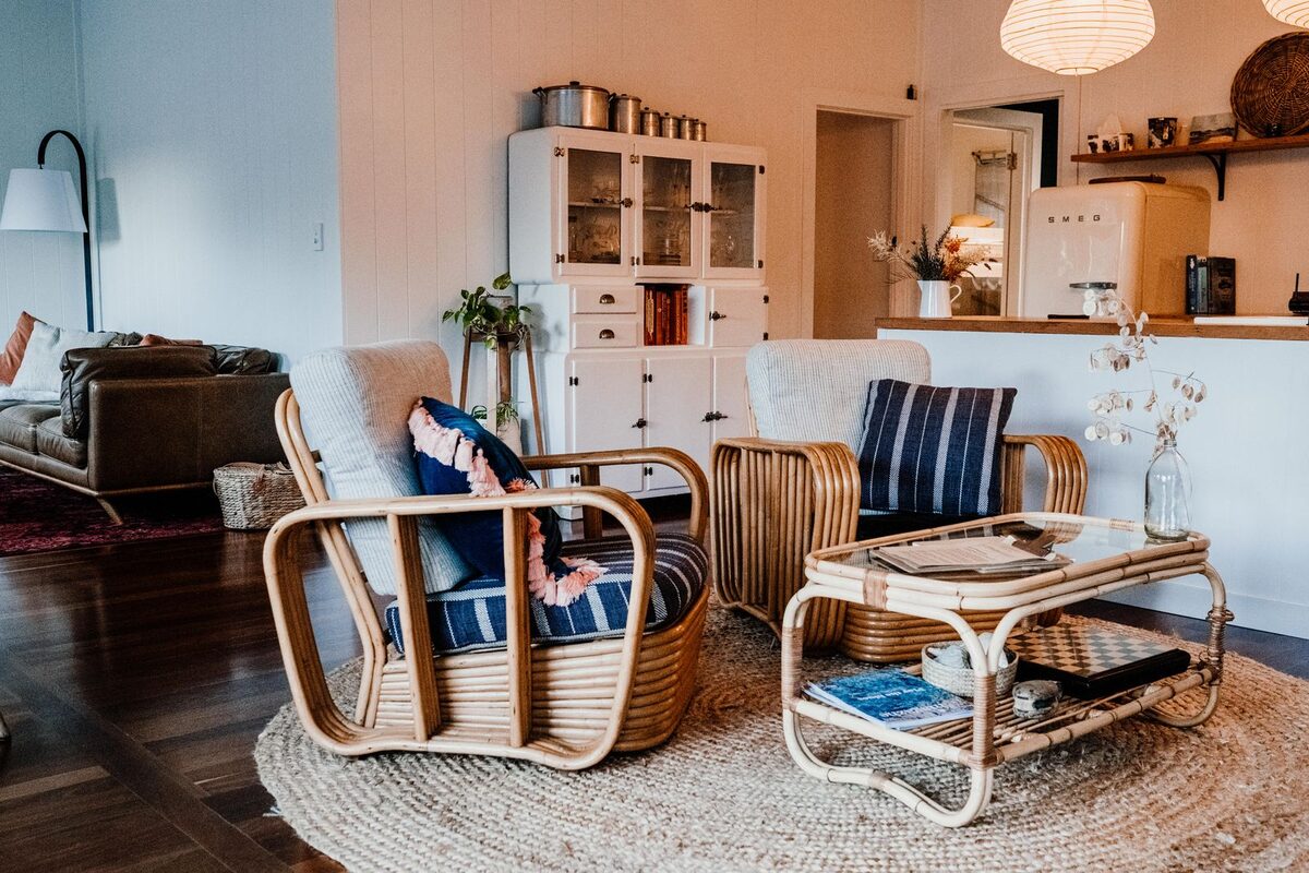 Sunlit lounge room at Villa Amara furnished with pale rattan seating and soft cushions
