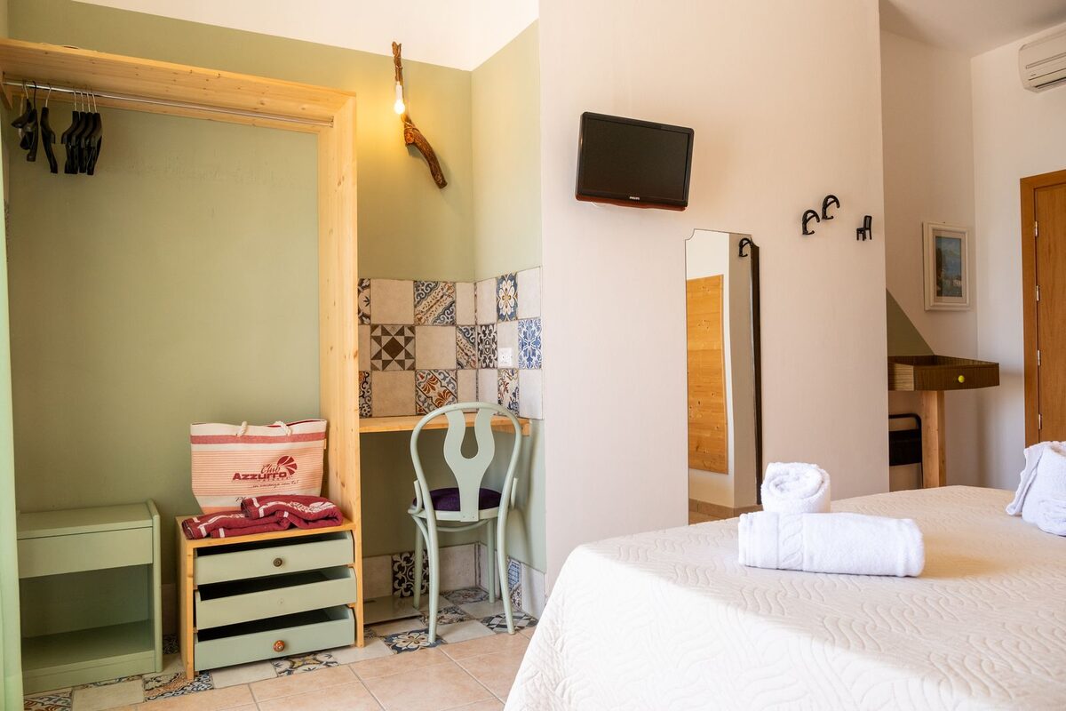 Bright twin room at Villa Amara with patterned encaustic floor tiles and two neatly made beds