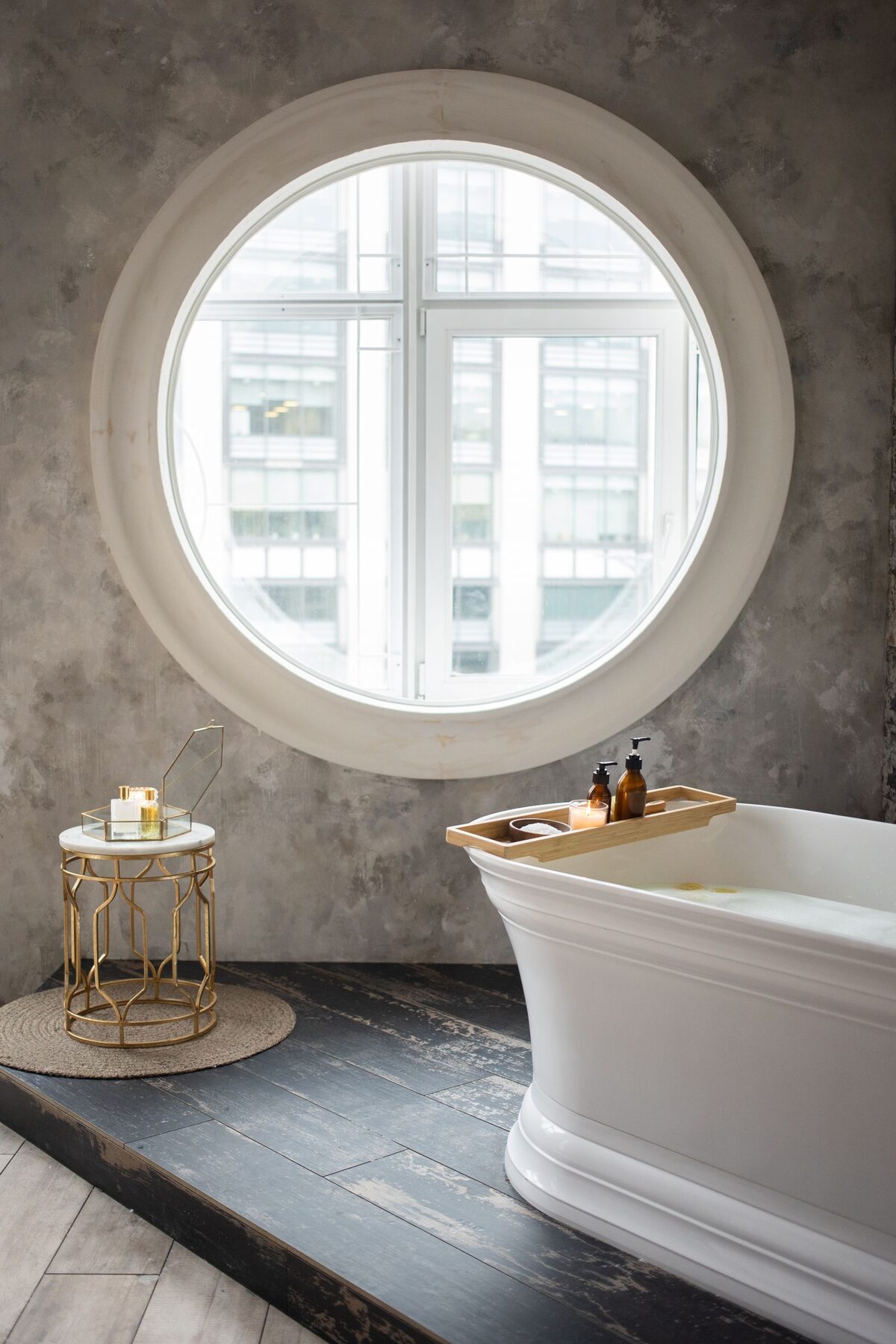 Bathroom with a round porthole window casting soft daylight over the basin
