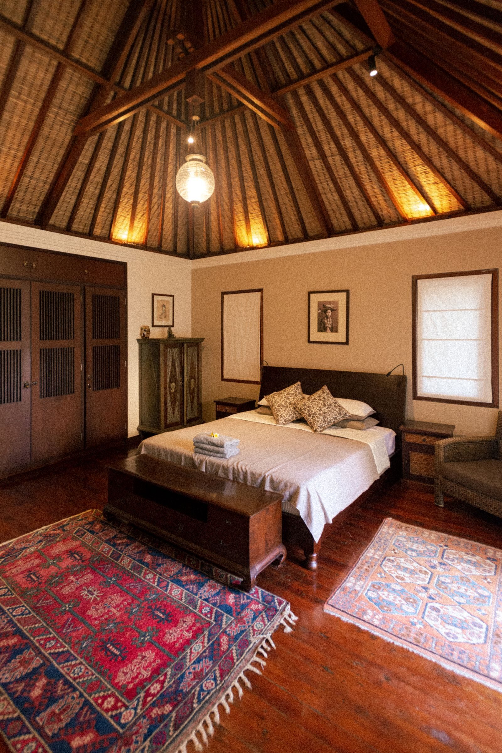 Cosy Villa Amara bedroom with a warm wood ceiling glowing under soft lamplight